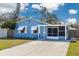 Charming blue home featuring a screened-in porch and a well-maintained front yard at 358 51St N Ave, St Petersburg, FL 33703