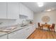 Well lit modern kitchen with white cabinets, stainless steel sink, subway tile backsplash, and wood floor at 358 51St N Ave, St Petersburg, FL 33703