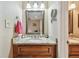 Well-lit bathroom vanity with granite countertops, wood cabinets, and framed mirror at 36750 Us Highway 19 N # 19308, Palm Harbor, FL 34684