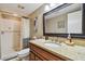 Well-lit bathroom features granite countertops, a decorative mirror, and a tiled walk-in shower with modern fixtures at 36750 Us Highway 19 N # 19308, Palm Harbor, FL 34684