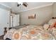 Bedroom featuring patterned bedding, a ceiling fan, and access to an ensuite bathroom and walk-in closet at 36750 Us Highway 19 N # 19308, Palm Harbor, FL 34684