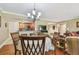 Cozy dining area with chandelier, wooden chairs, and view to the adjacent kitchen, perfect for everyday meals at 36750 Us Highway 19 N # 19308, Palm Harbor, FL 34684