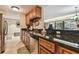 Galley kitchen with stone countertops and stainless steel dishwasher, seamlessly flowing into the dining room at 36750 Us Highway 19 N # 19308, Palm Harbor, FL 34684