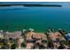 Wide aerial view showcasing a waterfront property, private docks, and tropical landscaping at 4998 62Nd S Ave, St Petersburg, FL 33715