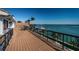 Expansive wooden deck with black railings offers stunning waterfront views and outdoor seating at 4998 62Nd S Ave, St Petersburg, FL 33715