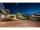 Well-lit home with a circular driveway, carport, and tropical landscaping at night at 4998 62Nd S Ave, St Petersburg, FL 33715