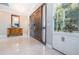 Elegant foyer features double doors, marble floors, display case and a decorative table with mirror at 4998 62Nd S Ave, St Petersburg, FL 33715