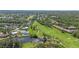 Aerial view showcasing a lush golf course and a residential area, featuring serene lakes and beautiful landscaping at 5310 Huntingwood Ct # 40, Sarasota, FL 34235