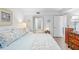 Bright bedroom featuring a comfortable bed, beach-themed art, and an open doorway to the bathroom at 5310 Huntingwood Ct # 40, Sarasota, FL 34235