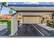 Carport area with a convenient parking space and storage, complemented by green landscaping at 5310 Huntingwood Ct # 40, Sarasota, FL 34235