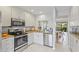 Well-lit kitchen with granite counters, stainless steel appliances, and a pass-through window at 5310 Huntingwood Ct # 40, Sarasota, FL 34235