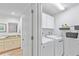 Convenient laundry room with washer, dryer, storage cabinets, and adjacent bathroom at 5310 Huntingwood Ct # 40, Sarasota, FL 34235