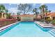 Community pool area with lounge chairs, lush landscaping, and clear blue water for relaxation at 5310 Huntingwood Ct # 40, Sarasota, FL 34235