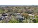 This aerial view shows the townhome nestled among lush trees and greenery, with a backdrop of buildings in the distance at 6218 Greenleaf Ln # 6218, Temple Terrace, FL 33617