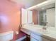 Bathroom with white vanity, sink, mirror and pink accent wall at 6218 Greenleaf Ln # 6218, Temple Terrace, FL 33617