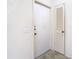 Bright hallway featuring a utility closet and a door, highlighting practical storage solutions and neutral wall color at 6218 Greenleaf Ln # 6218, Temple Terrace, FL 33617