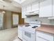 Well-lit kitchen features bright cabinets, range appliances, and tile flooring at 6218 Greenleaf Ln # 6218, Temple Terrace, FL 33617