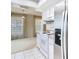 Open kitchen with stainless steel refrigerator and white appliances, seamlessly blending with a cozy dining area at 6218 Greenleaf Ln # 6218, Temple Terrace, FL 33617