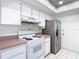This kitchen features white cabinetry, stainless steel appliances, and updated countertops at 6218 Greenleaf Ln # 6218, Temple Terrace, FL 33617
