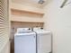 Laundry room with white washer and dryer units and built-in shelving at 6218 Greenleaf Ln # 6218, Temple Terrace, FL 33617
