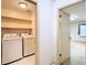 Well-equipped laundry room with washer, dryer, and built-in shelving at 6218 Greenleaf Ln # 6218, Temple Terrace, FL 33617
