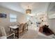 Open-concept dining room featuring neutral color palette, a view of the kitchen, and modern chandelier at 8413 N Hamner Ave # A, Tampa, FL 33604
