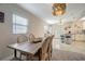Open-concept dining room with polished tile floors, a wooden dining table and a pendant chandelier at 8413 N Hamner Ave # A, Tampa, FL 33604