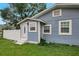 Close-up view of blue home side featuring exterior door and window at 8413 N Hamner Ave # A, Tampa, FL 33604