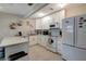 Updated kitchen featuring white cabinets, tile backsplash, an island with seating, and stainless appliances at 8413 N Hamner Ave # A, Tampa, FL 33604