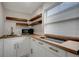 Modern kitchen featuring white cabinets, butcher block countertops, and a stylish cooktop and microwave at 8413 N Hamner Ave # A, Tampa, FL 33604