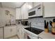 Close-up of the kitchen featuring white appliances, white backsplash and white upper and lower cabinets at 8413 N Hamner Ave # A, Tampa, FL 33604
