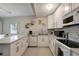 Well-lit kitchen features white cabinetry, stainless steel appliances, and modern backsplash at 8413 N Hamner Ave # A, Tampa, FL 33604