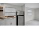 Clean kitchenette area with stainless steel refrigerator, cooktop, and white cabinets at 8413 N Hamner Ave # A, Tampa, FL 33604