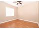 Simple bedroom featuring hardwood floors, neutral paint, a ceiling fan and a bright window at 946 Allegro Ln, Apollo Beach, FL 33572