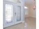 Bright foyer with tile flooring, decorative glass front doors and chandelier at 946 Allegro Ln, Apollo Beach, FL 33572