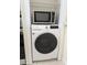 Stacked white Samsung washer and dryer with a microwave above at 10500 77Th Ter # 232, Seminole, FL 33772