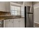 Kitchen showcasing stainless steel refrigerator, granite countertops, and white cabinetry at 10530 77Th Ter # 224, Seminole, FL 33772