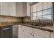 This kitchen features modern finishes with granite counters, white cabinets and stainless dishwasher at 10530 77Th Ter # 224, Seminole, FL 33772
