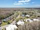 Aerial view of a neighborhood with houses, trees, a pond and parked cars on a sunny day at 12738 Wood Trail Blvd, Tampa, FL 33625