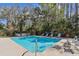 Community pool surrounded by lush greenery and comfortable lounge chairs for residents to enjoy at 12738 Wood Trail Blvd, Tampa, FL 33625