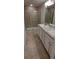 Bright bathroom with a double sink vanity, a mirror, and a glass-enclosed shower at 13052 Ogden Glade Rd, Dade City, FL 33525
