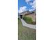 Landscaped front yard with green grass and ornamental plants leading to a cozy front porch at 13052 Ogden Glade Rd, Dade City, FL 33525