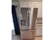 Stainless steel refrigerator with dispenser, adjacent to white cabinets at 13052 Ogden Glade Rd, Dade City, FL 33525