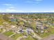 An aerial view showcasing a neighborhood with lush landscaping, waterfront properties, and a glimpse of the ocean at 1500 Carson Ne Cir, St Petersburg, FL 33703