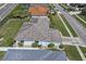 Aerial view featuring a grey shingled roof, well-maintained yard, and adjacent neighborhood street at 1614 Oracle Dr, Sun City Center, FL 33573