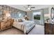 Serene main bedroom featuring a large window, ceiling fan and stylish wallpaper at 17257 Bigleaf Mahogany Ln, Land O Lakes, FL 34638