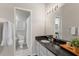 Bathroom with dark granite countertop, white cabinets, tile flooring, and modern mirror and lighting at 18903 Duquesne Dr, Tampa, FL 33647