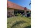 Backyard view featuring a grill and patio set outside of the condo's wall of glass doors and red tile roof at 19029 Us Highway 19 N # 12E, Clearwater, FL 33764