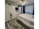 Bright bedroom featuring wood-look floors, white furniture, and ceiling fan at 19029 Us Highway 19 N # 12E, Clearwater, FL 33764