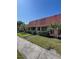 Charming villa with red tile roof, lush landscaping, and a well-manicured lawn at 19029 Us Highway 19 N # 12E, Clearwater, FL 33764